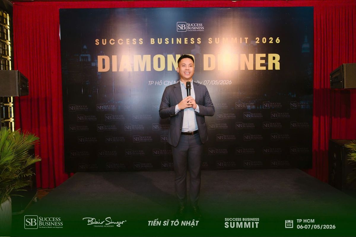 Lê Văn Cương cầm micro phát biểu trước backdrop Success Business Summit 2026 Diamond Dinner